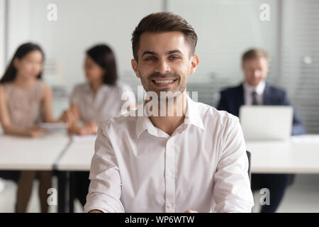 Portrait of smiling young team leader sitting at office. Stock Photo