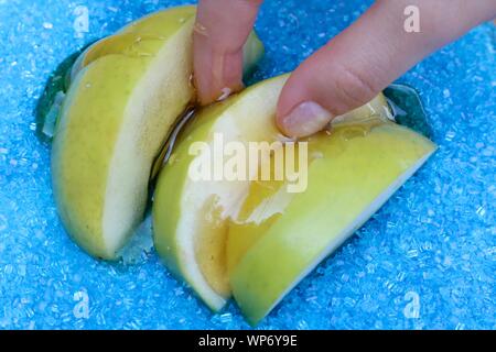 Little fingers grabbing apple slices dipped in honey for Jewish New Year Stock Photo