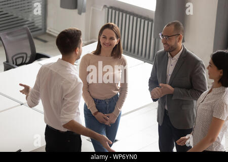 Confident team leader explaining work moments to employees. Stock Photo