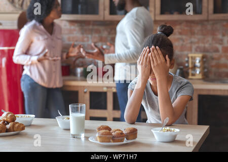 African girl crying at kitchen as parents fighting Stock Photo