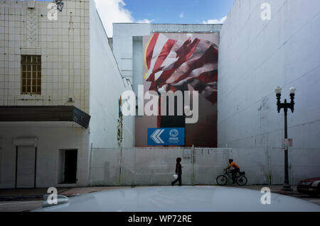 Man covered by American flag, mural by Conor Harrington in Downtown Miami, installed in 2017 next to former Macy's building (right side of the image). Stock Photo