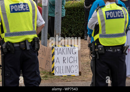 Making a rich killing placard at Defence & Security Equipment International DSEI arms fair trade show, ExCel, London, UK. Police cordon Stock Photo