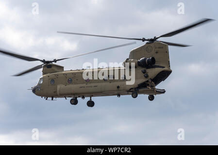 US Army Boeing CH-47F Chinook helicopter landing at Defence & Security Equipment International DSEI arms fair trade show, ExCel, London, UK. Crewman Stock Photo