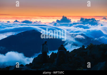 People watching clouds at sunrise from the top of Haleakala Crater on Maui, Hawaii, USA Stock Photo