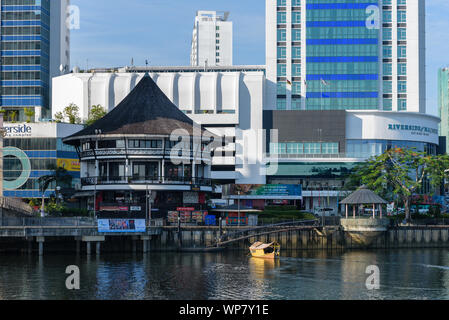 Kuching, Sarawak / Malaysia - July 29, 2019: A riverboat (locally known as perahu tambang or penambang) is approaching a pontoon to cross Sarawak rive Stock Photo