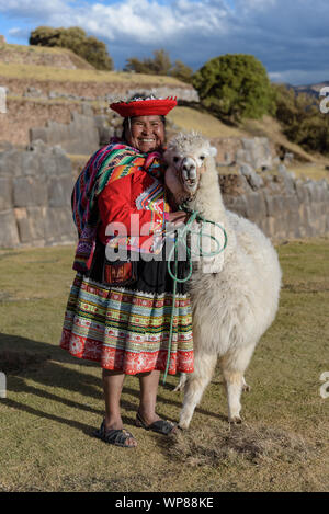 Cuzco, Peru - July 14, 2018. Peruvian woman dressed in traditional colourful clothes with alpaca / llama at Sacsayhuaman, Cusco, Peru, South America. Stock Photo