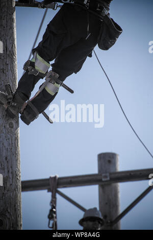 Power linemen working on a utility pole Stock Photo