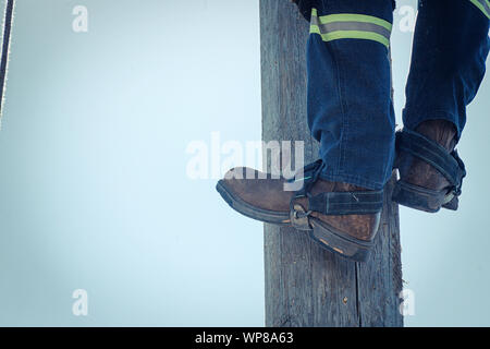 Electrician lineman at climbing work on electrical power pole Stock ...