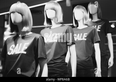 Female mannequins in T-shirts with the inscription 'Sale' announcing discounts at a shopping mall. Black and white photo. Stock Photo