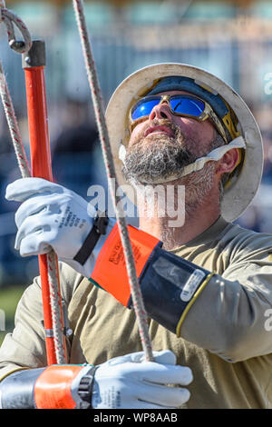 Construction worker at a job site holding a pole Stock Photo
