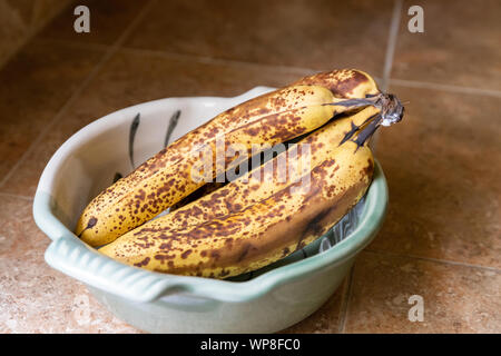 Bowl of ripe bananas on kitchen counter Stock Photo