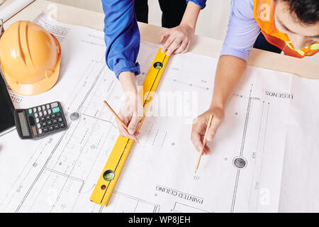 Hands of architect and civil engineer working on construction plan of building, view from above Stock Photo