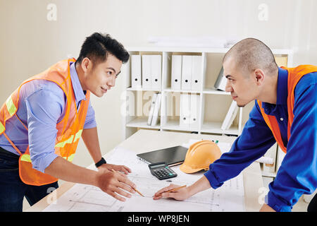 Head engineer and contractor having meeting in office and discussing construction plan and upcoming work Stock Photo