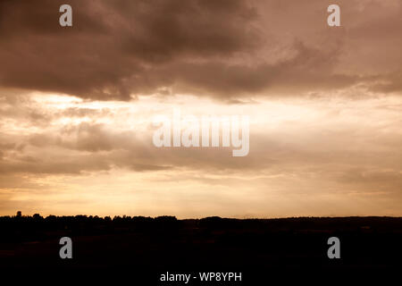 dramatic landscape in backlight with sunset over Roback in Umea with light pillars coming from the sky Stock Photo