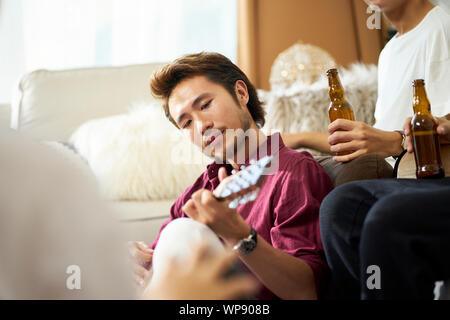 young asian adult men drinking beer at home Stock Photo