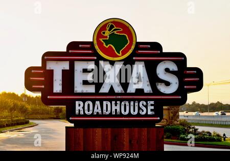 Houston, Texas/USA 09/06/2019: Texas Roadhouse restaurant sign on the side of a freeway in Humble, Texas during an early morning sunrise. Stock Photo