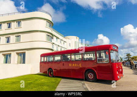 Historic Art Deco building of The Midland Hotel in Morecambe, England with retro red bus at the grounds during the Vintage By The Sea festival. Stock Photo