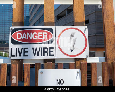 Danger live wire power lightning bolt warning sign posted near hazard Stock Photo