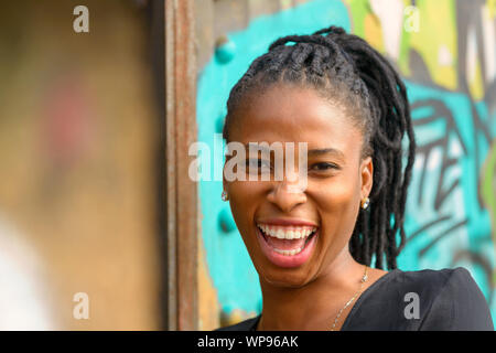 Attractive young African woman with a vivacious smile laughing at the camera Stock Photo
