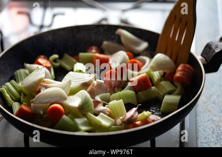Frying onion, celery, garlic and carrots in pan with olive oil