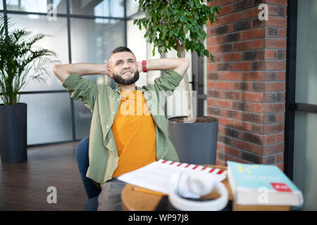 Bearded man feeling satisfied after studying at the weekend Stock Photo