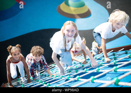 Children feeling involved in climbing all together Stock Photo