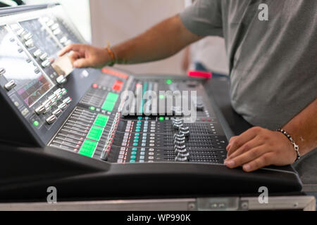 Male hand on control Fader on console. Sound recording studio mixing desk with engineer or music producer Stock Photo