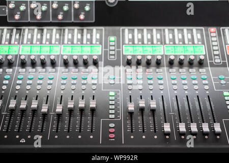 od adjusters and red buttons of a mixing console. It is used for audio signals modifications to achieve the desired output. Applied in recording Stock Photo