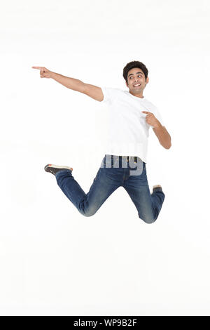 Young man jumping in air and smiling Stock Photo