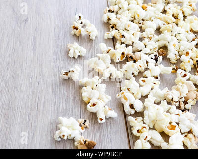 popcorn on wooden background, copy space. Scattered salted popcorn, texture background Stock Photo