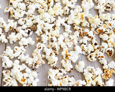 popcorn on wooden background, copy space. Scattered salted popcorn, texture background Stock Photo