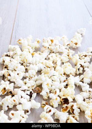 popcorn on wooden background, copy space. Scattered salted popcorn, texture background Stock Photo
