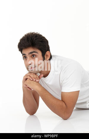 Young man thinking with lying on floor Stock Photo