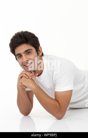 Young man lying down on the floor Stock Photo