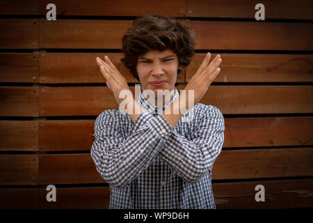 young man with crossed hands in front of face, stop gesture sign Stock Photo