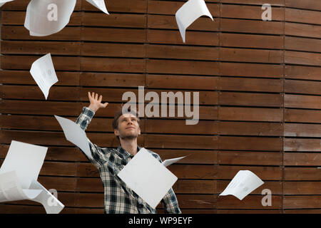 young stressed man throw crumpled paper files in the air, freedom concepts Stock Photo