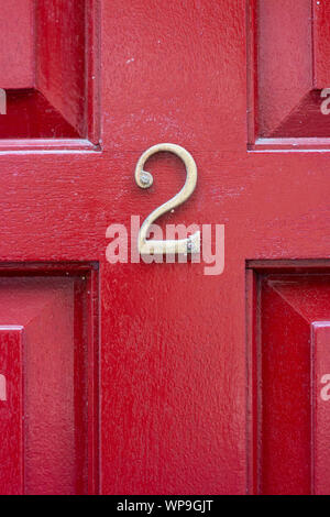 House number 2 on a bright red wooden front door Stock Photo