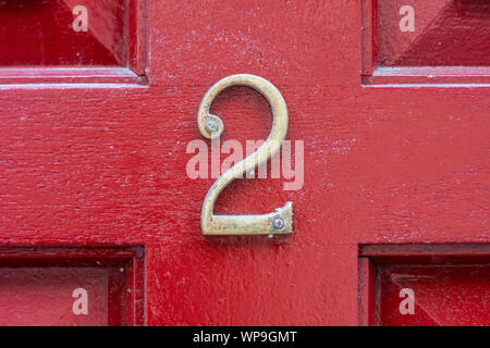 House number 2 on a bright red wooden front door Stock Photo