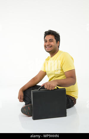 Young man smiling with suitcase Stock Photo