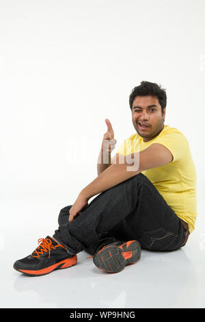 Young man pointing at camera and winking Stock Photo