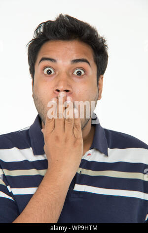 Surprised young man covering his mouth Stock Photo