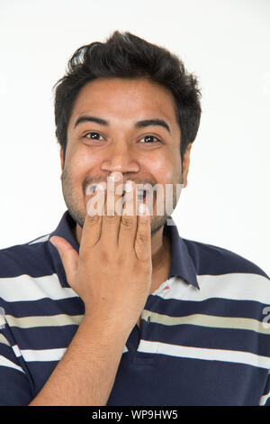 Surprised young man covering his mouth Stock Photo