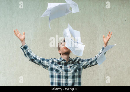 young stressed man throw crumpled paper files in the air, freedom concepts Stock Photo