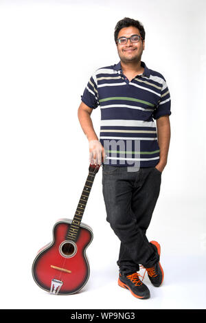 Young man leaning on a guitar Stock Photo
