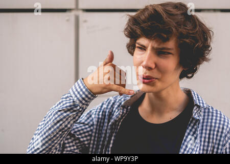 young guy showing a call me sign gesture finger, symbol of mobile phones Stock Photo