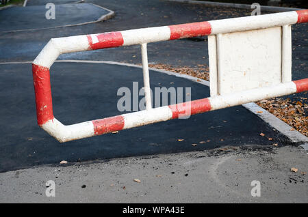 A red and white metal barrier before entering the private territory. Pavement repair, asphalt replacement Stock Photo
