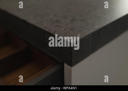 Closeup detail shot of gray terrazzo kitchen countertop with black marble, shallow focus Stock Photo