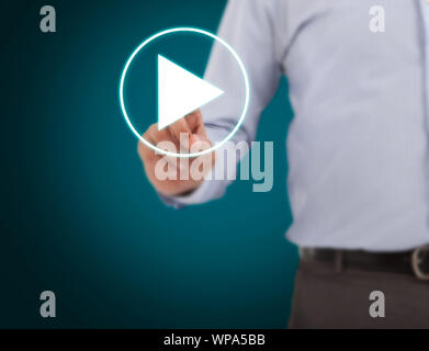 Mid section of a businessman pressing startplay button on virtual screen Stock Photo