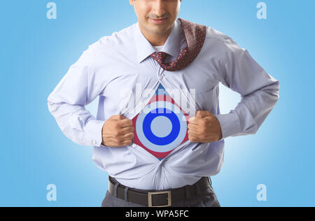 Super businessman tearing up his shirt to reveal dartboard on chest Stock Photo