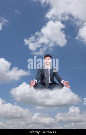Businessman sitting on clouds practicing yoga Stock Photo